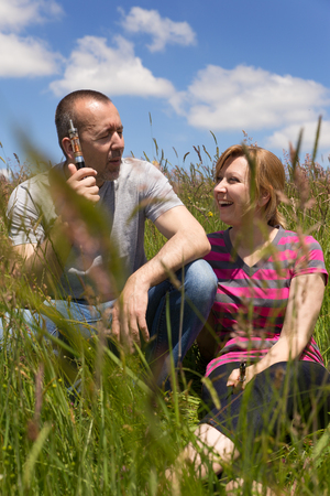 adult couple with e-cigarette in a meadowの写真素材