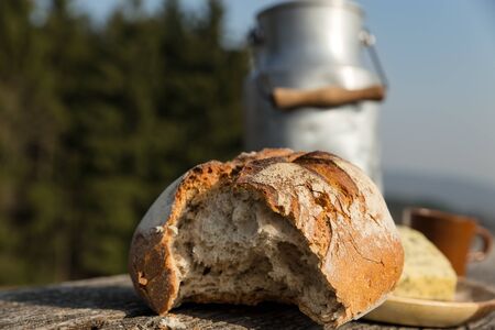 a rustically bread and milk churn on a wooden table