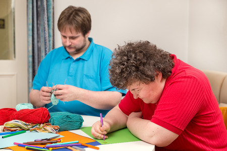 a mentally disabled woman and young man doing arts and craftsの写真素材