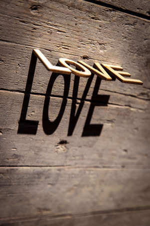 wooden letters on old aged wooden table build the shadow word love, vintage styleの写真素材