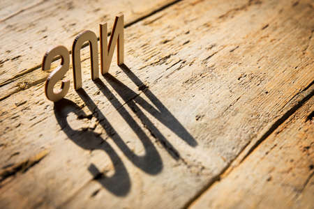 wooden letters on old aged wooden table build the shadow word sun, vintage styleの写真素材