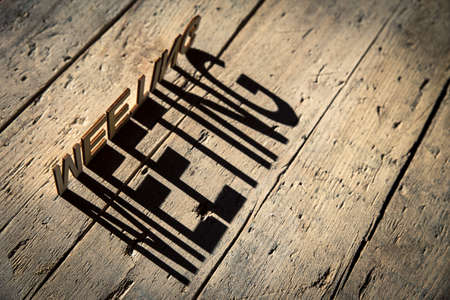 wooden letters on old aged wooden table build the shadow word meeting, vintage styleの写真素材