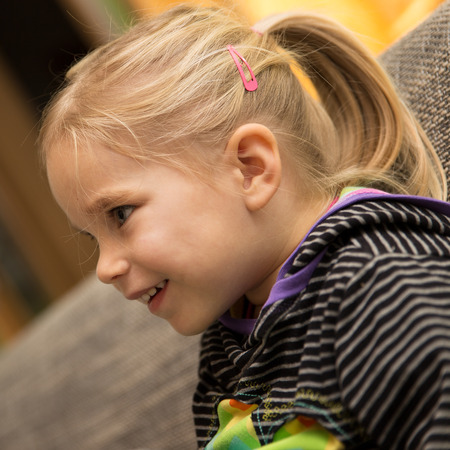 Portrait of a cute blond girl at homeの写真素材