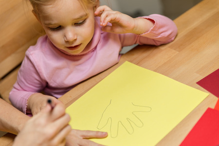 Mother and daughter are drawing theirs handsの写真素材