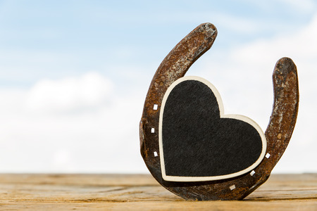 horseshoe in front of blues sky with heart and space for textの写真素材