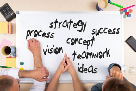 whiteboard with business words, three persons, overview of an desk topの写真素材