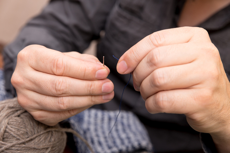 closeup of a man with a needle and threadの写真素材