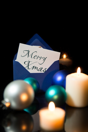 Festive christmas decoration in blue and white, lightning candles, christmas balls and black backgroundの写真素材