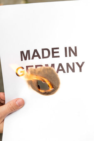 lighted paper made in germany, lies on the ground, concept betrayal of confidenceの写真素材