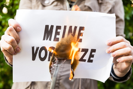 Woman is holding a burning paper with german text meine vorsaetze, means my resolutionsの写真素材
