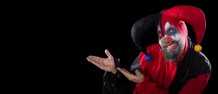 funny Jester showing to copyspace, concept halloween and horror, black backgroundの写真素材