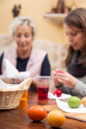 women painting easter eggs in the living roomの写真素材