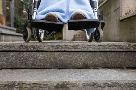 woman in wheelchair in problems, cannot pass stairsの写真素材