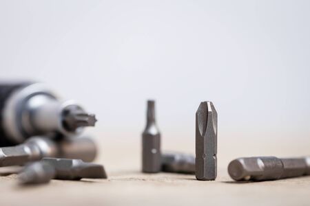 screwdriver with different bits on a wooden tableの写真素材