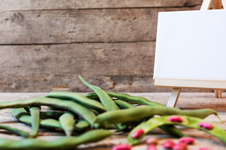 garden beans on a wooden table with empty board