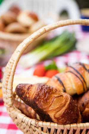 butter and chocolate croissants in a basket on a breakfast tableの写真素材