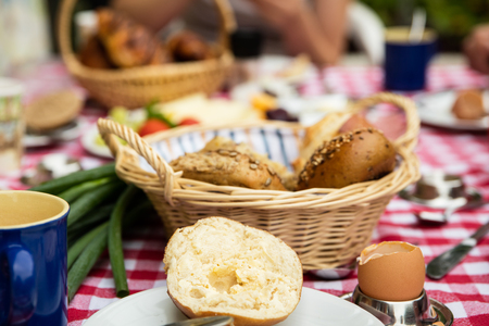 breakfast table with cheese, sausage, coffee and vegetablesの写真素材