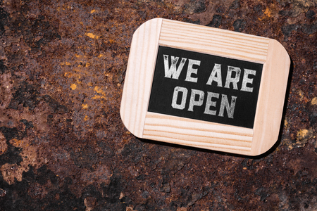 slate on rusty background, english text we are open
