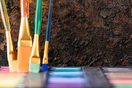paint brushes and color box, rusty backgroundの写真素材