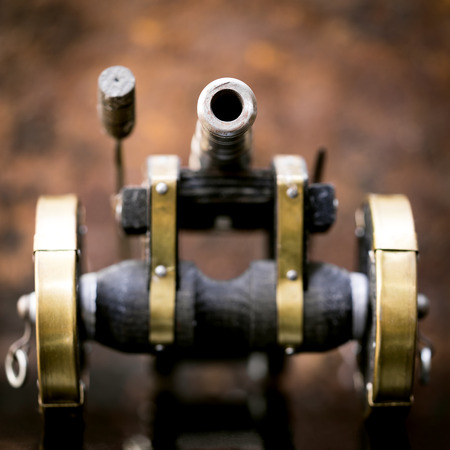 miniature cannon, closeup for a military toy, brown backgroundの写真素材
