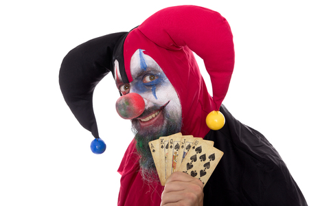 a madly Fool holding playing cards, concept gambling, isolated on whiteの写真素材