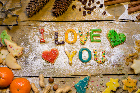 Cookie letters with christmas decoration on wooden table, text i love youの写真素材