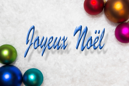 colorful christmas balls in the snow, french words joyeux noel, which means merry christmasの写真素材