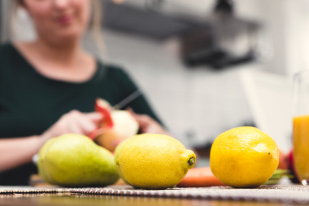 preparation of a fresh smoothie at home, woman peeling a apple