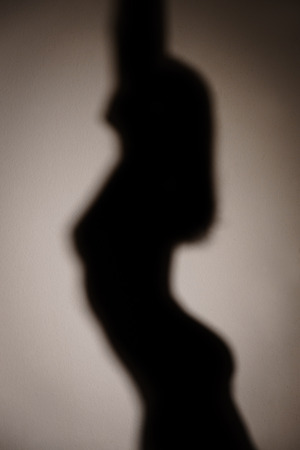 Silhouette, woman dancing striptease, poledance or nude erotic dance, shadowの写真素材