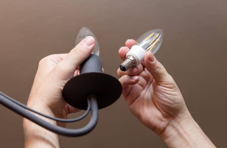 Man is changing a light bulb, energy saving lamp, Electricityの写真素材