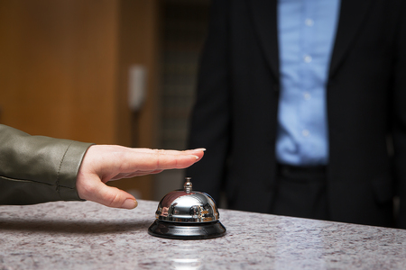 visitor in hotel is using the bell at the receptionの写真素材