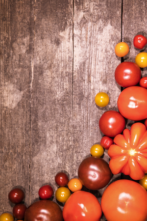 various tomatoes on a rustic, wooden backgroundの写真素材