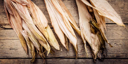 Brown and yellow corncob on wooden background, panoramaの写真素材