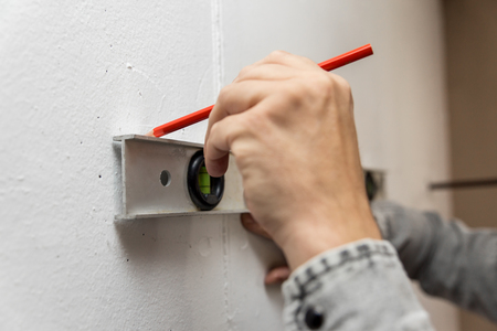 tagging to the wall with a bubble level and pen, closeupの写真素材