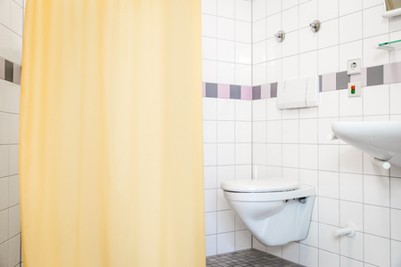 empty bathroom with toilet and shower in a hospital or care homeの写真素材