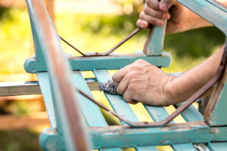 Finishing with steel wool to get a shabby chic look on an old, wooden sledgeの写真素材