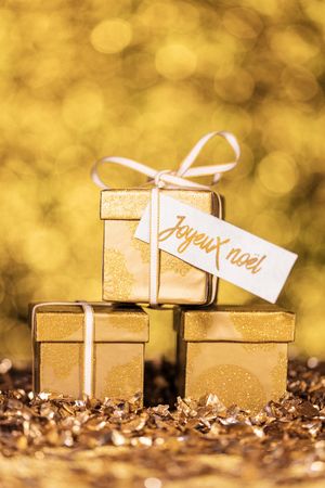 three golden gifts with french text which means merry christmasの写真素材