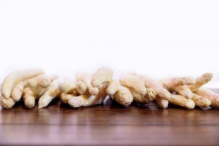 lots of white asparagus on wooden table, white background with copyspaceの写真素材