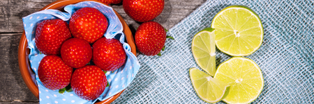 Panorama flatlay, Strawberries and Lime on blue burlap backgroundの写真素材