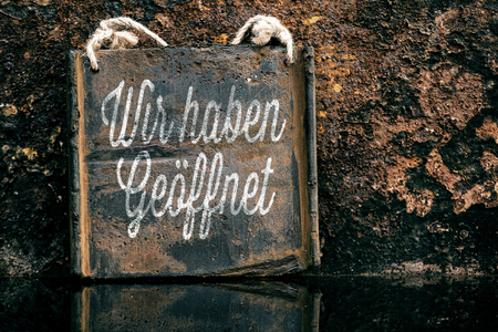 Vintage sign with german text which means we are open, rusty backgroundの写真素材