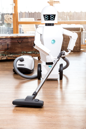 ambient assisted living roboter is vacuuming the floor of the living roomの写真素材