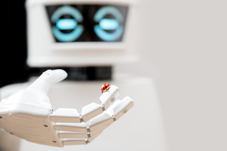 robot with ladybug on his finger is thinking about lifeの写真素材