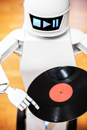 music robot is playing a record while touching with his finger the record. Cocept music streaming or downloading, futuristic music playerの素材 [FY31099484485]