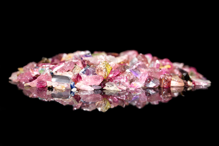 Many colorful Tourmaline splinter in front of black background with reflections and copyspaceの写真素材