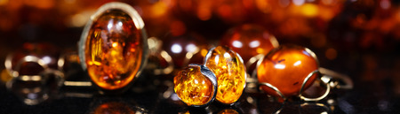 panorama of jewelry with amber stones, amber necklace ring and earring and pendant with noble metal...