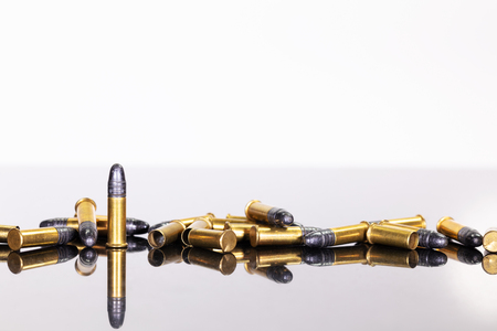 group of ammunition on a table with reflections, white background