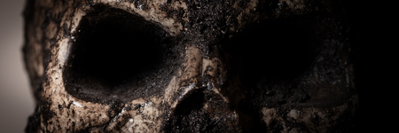 Panorama with close-up of a human skull, empty gloomy eye sockets of a skullの写真素材