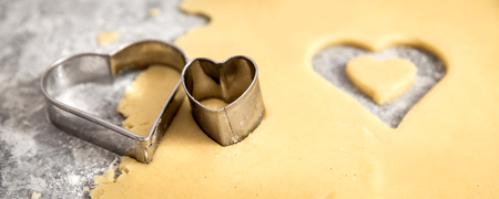 Header, cookie dough and metallic heart shape cutters, concept baked with loveの写真素材
