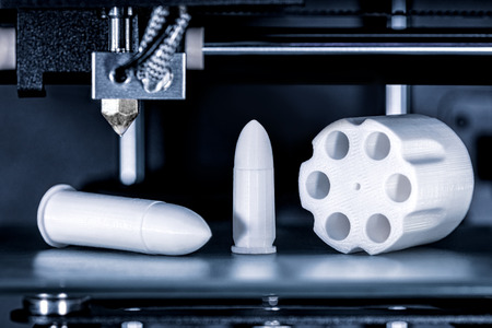 Cartridges and revolver drum are printed in a 3D printer, concepts such as arms trade and weapons...