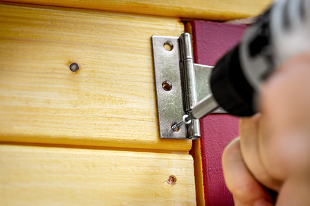 Hinge Door fitting or cross hanger is screwed to a door with an electric screwdriver